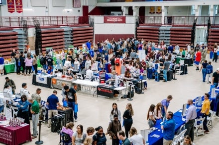 A room full of high school juniors and seniors asking college and university representatives about school options.