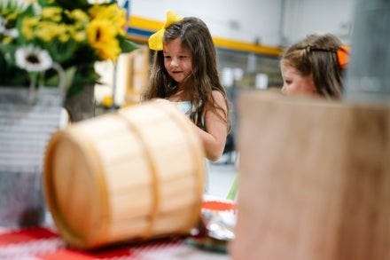 Two students looking at plants and baskets on a table.