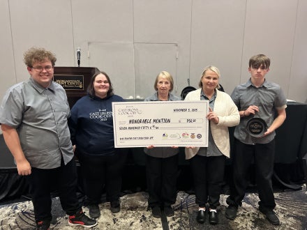 People holding a prize check for being named an honorable mention.