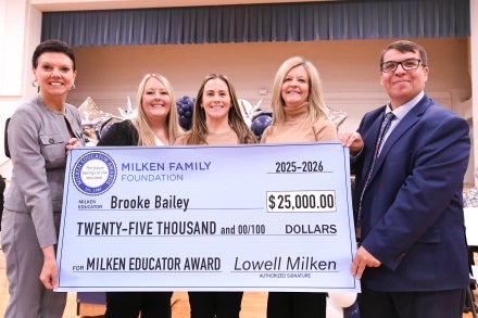 Brooke Bailey, Michele Blatt, and others holding a $25,000 check.