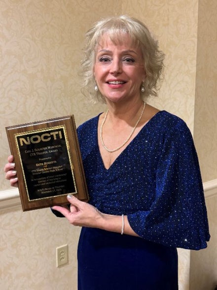 Beth Roberts holding an award.