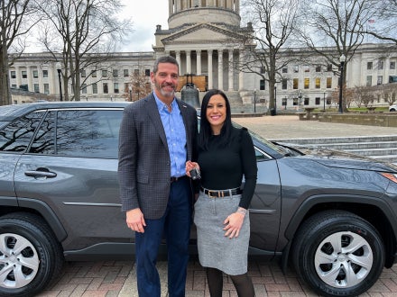 David Rosier and Tiffany Barnes smiling while standing in front of a Toyota RAV4.