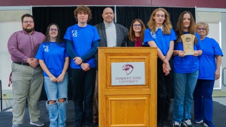 Members of Fairmont Senior High School's Academic Showdown team holding a trophy.