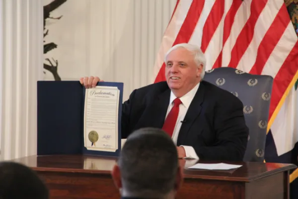 Governor Jim Justice holds up a signed bill