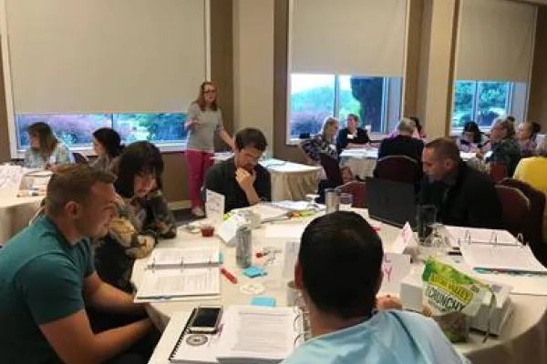 Educators sitting around a table at a National Board Certification training hosted by the WV Department of Education