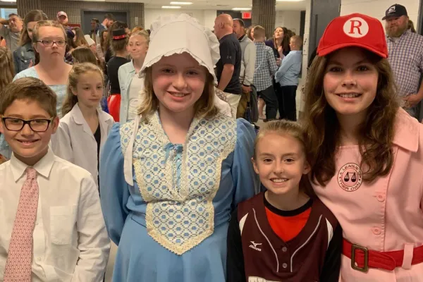 Four children smiling for the camera at the social studies fair.