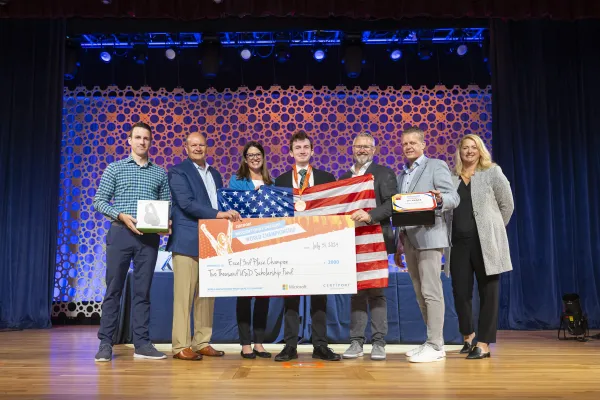 Pictured is Andrew Manteau receiving a third place prize while holding an American flag.
