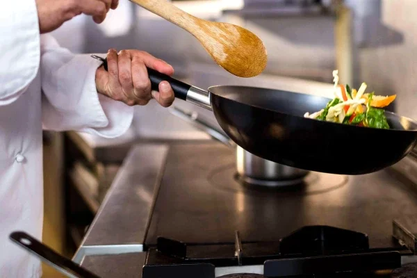Chef cooking at industrial grill