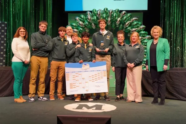 Group of Huntington High School students together with teachers celebrating win on stage
