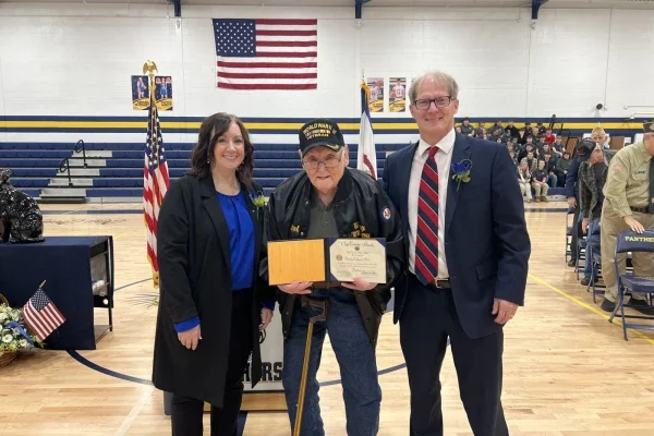 Phoebe Nichols, Charles Bird and Phil Dobbins pose for a photo with Bird’s high school diploma.
