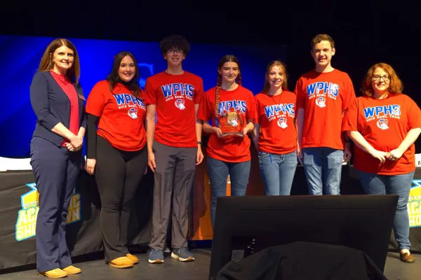 Team of students standing together with an award.