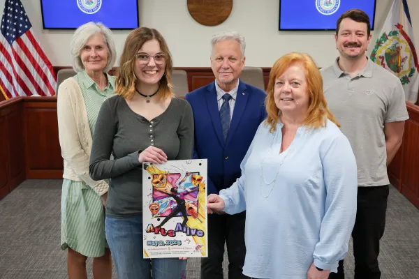 2025 Arts Alive poster contest winner posing with the winning poster with staff from the WV Department of Education