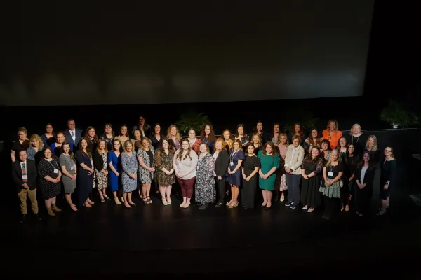 National Board Certification honorees standing together on stage at 2025 celebration