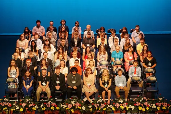 A group of students sitting in chairs on a stage.
