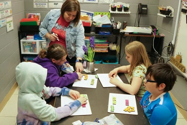 A teacher helping students with math.