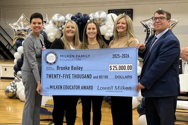 Brooke Bailey, Michele Blatt, and others holding a prize check for $25,000.