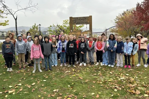 Students standing outside around a swing.