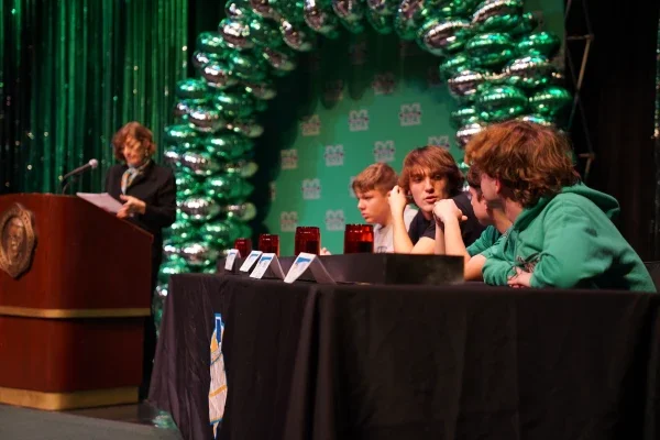 Students sitting at a table talking to one another.