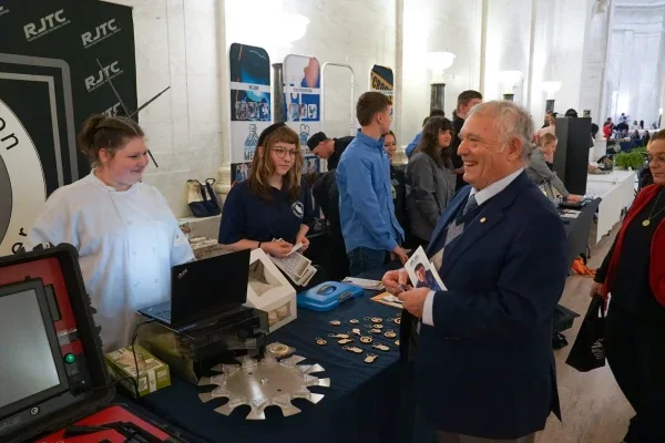 People laughing and smiling at a table inside the West Virginia State Capitol.