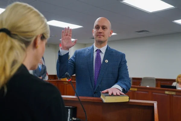 Dr. James Pauls holding his right hand up and placing his left on the Bible during his oath of office as the newest West Virginia Board of Education member.