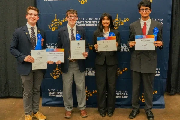 Joseph Nodurft, Jaxon Milam, Iqraa Zaman and Pavan Subramani smiling while holding certificates..