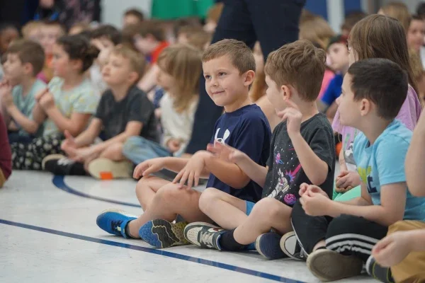 Students sitting on the floor and smiling