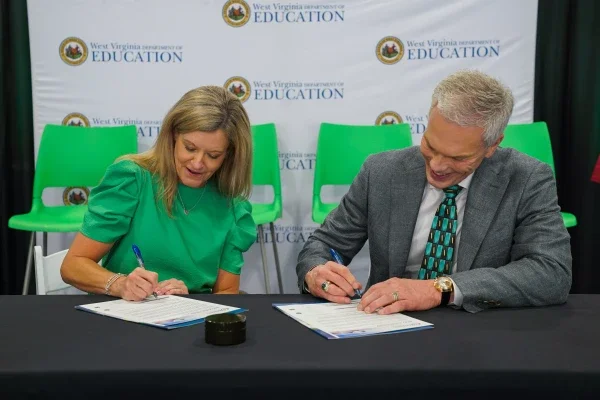 Michele Blatt and Brad Smith signing documents. 