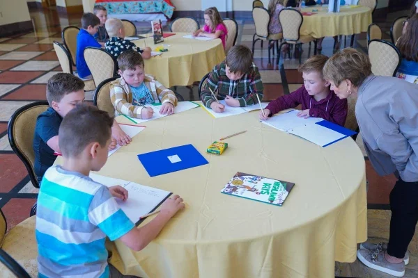 Students sitting at a table writing. 