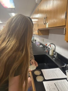 A student standing in front of a science project.