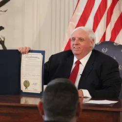 Governor Jim Justice holds up a signed bill