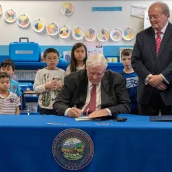Governor Jim Justice signs paper at a classroom