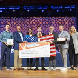 Pictured is Andrew Manteau receiving a third place prize while holding an American flag.