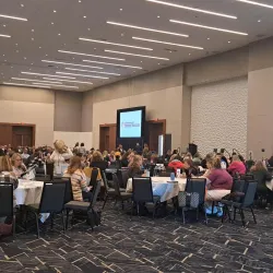 Student Support Conference attendees gather at tables in a large auditorium.