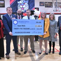 Milken winner holds a check