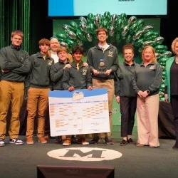 Group of Huntington High School students together with teachers celebrating win on stage