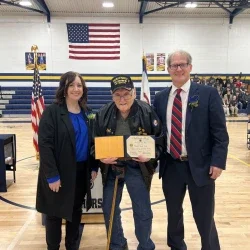Phoebe Nichols, Charles Bird and Phil Dobbins pose for a photo with Bird’s high school diploma.