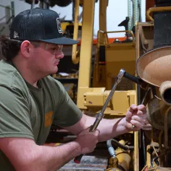 Man working on a motor with socket wrenches.