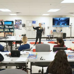 A woman teaching nursing students front the front of the classroom.