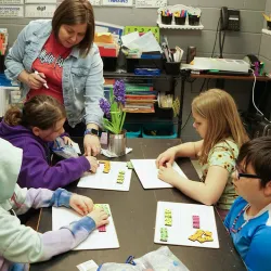 A teacher helping students with math.