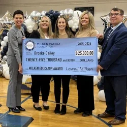 Brooke Bailey, Michele Blatt, and others holding a prize check for $25,000.