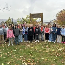 Students standing outside around a swing.