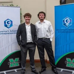 Two people standing in front of Governor's School of Entrepreneurship banners.