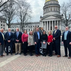 David Rosier, Tiffany Barnes, and West Virginia Board of Education members smiling while standing in front of a Toyota RAV4.