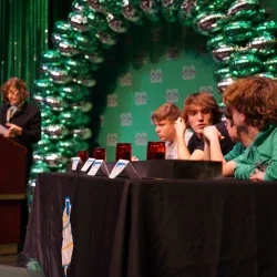 Students sitting at a table talking to one another.