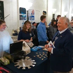 People laughing and smiling at a table inside the West Virginia State Capitol.
