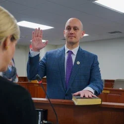 Dr. James Pauls holding his right hand up and placing his left on the Bible during his oath of office as the newest West Virginia Board of Education member.