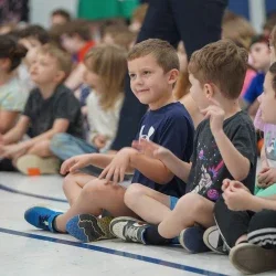 Students sitting on the floor and smiling