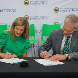 Michele Blatt and Brad Smith signing documents. 