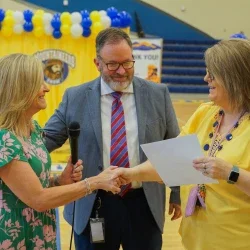 Michele Blatt shaking someone's hand while giving them a certificate. 