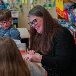 A school principal smiling at students. 